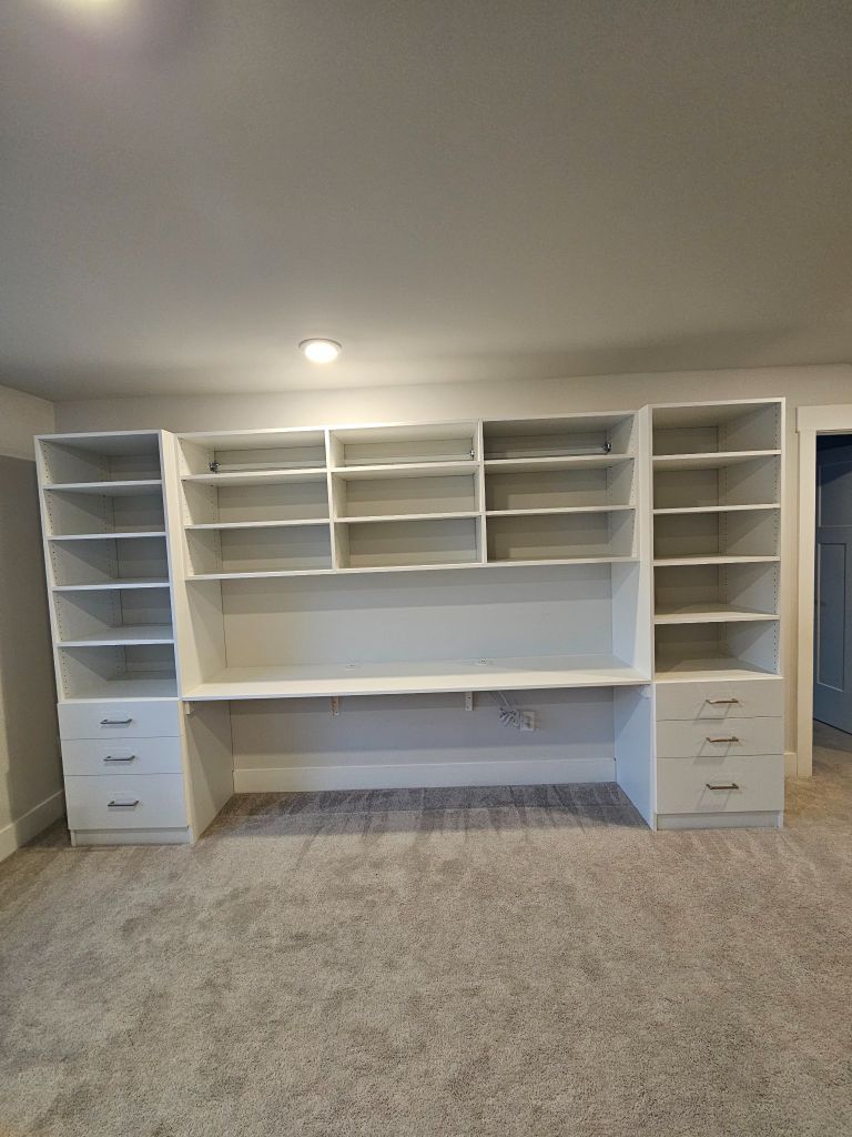 Custom built-in shelving and desk unit in a room.