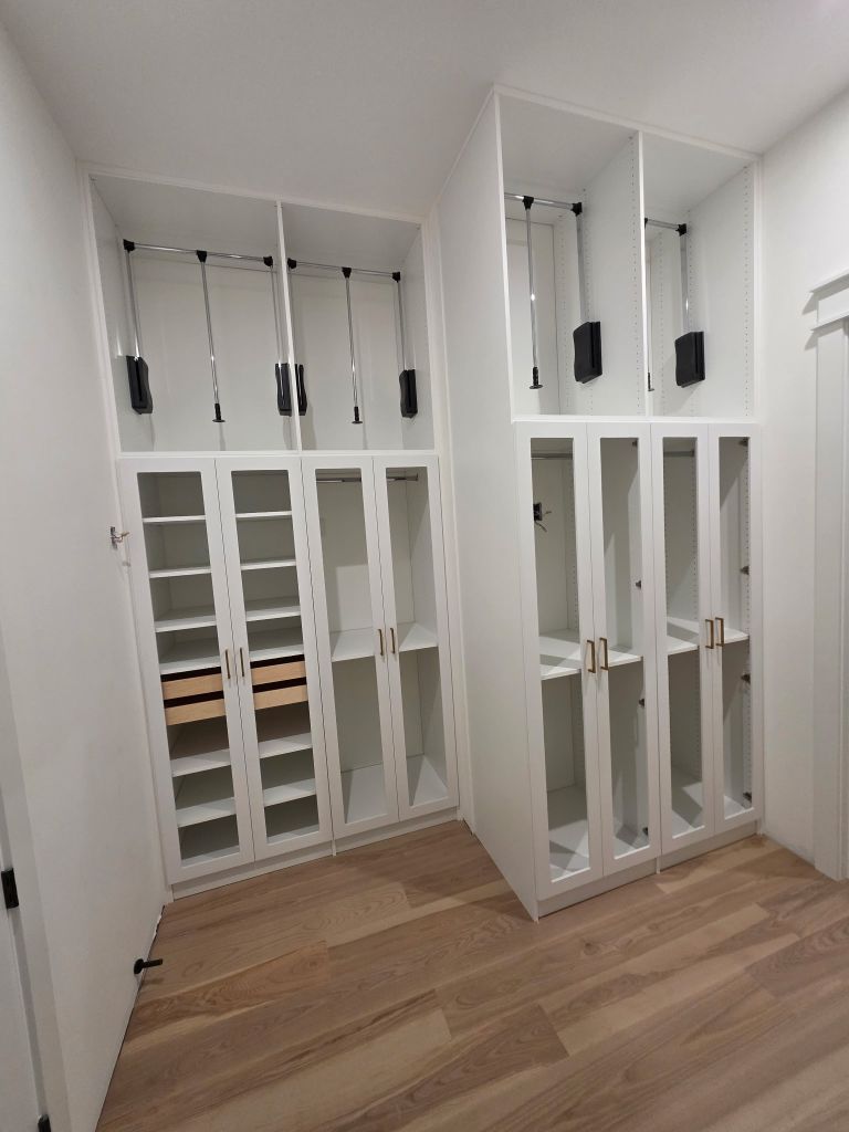 Minimalist white built-in shelving units in a modern room.
