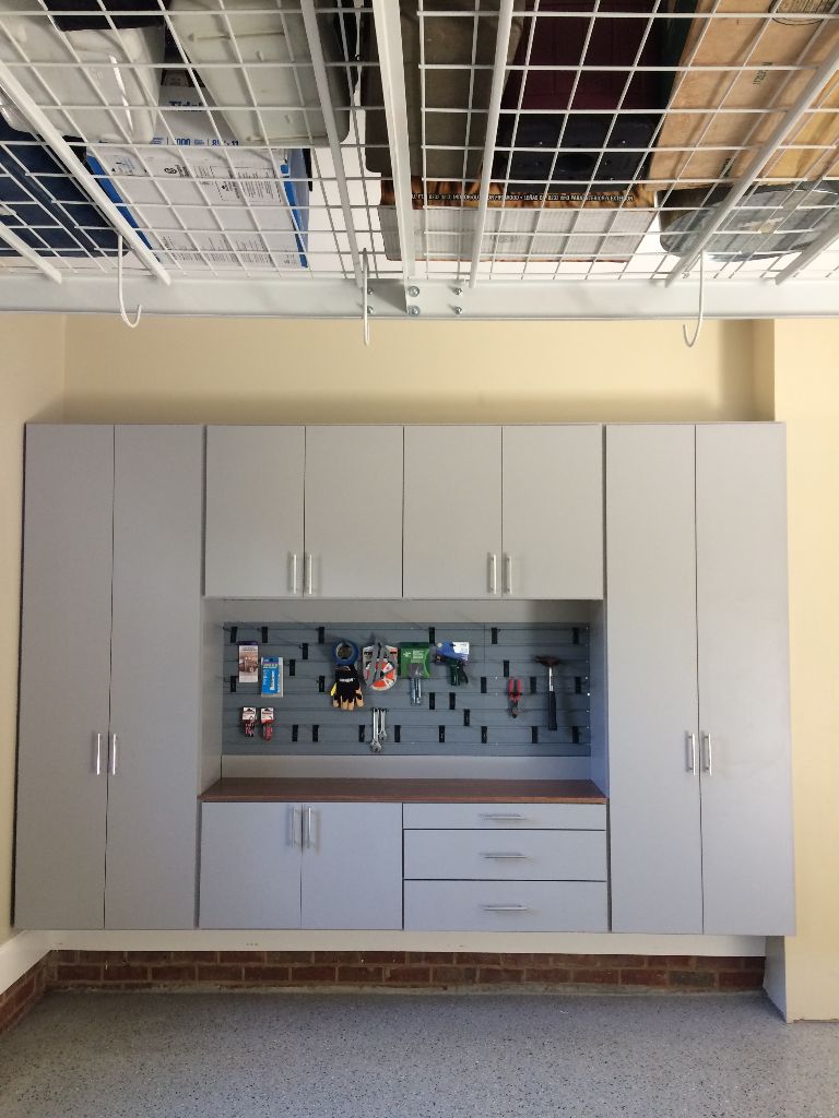 A modern kitchen setup with gray cabinets and a tiled backsplash.