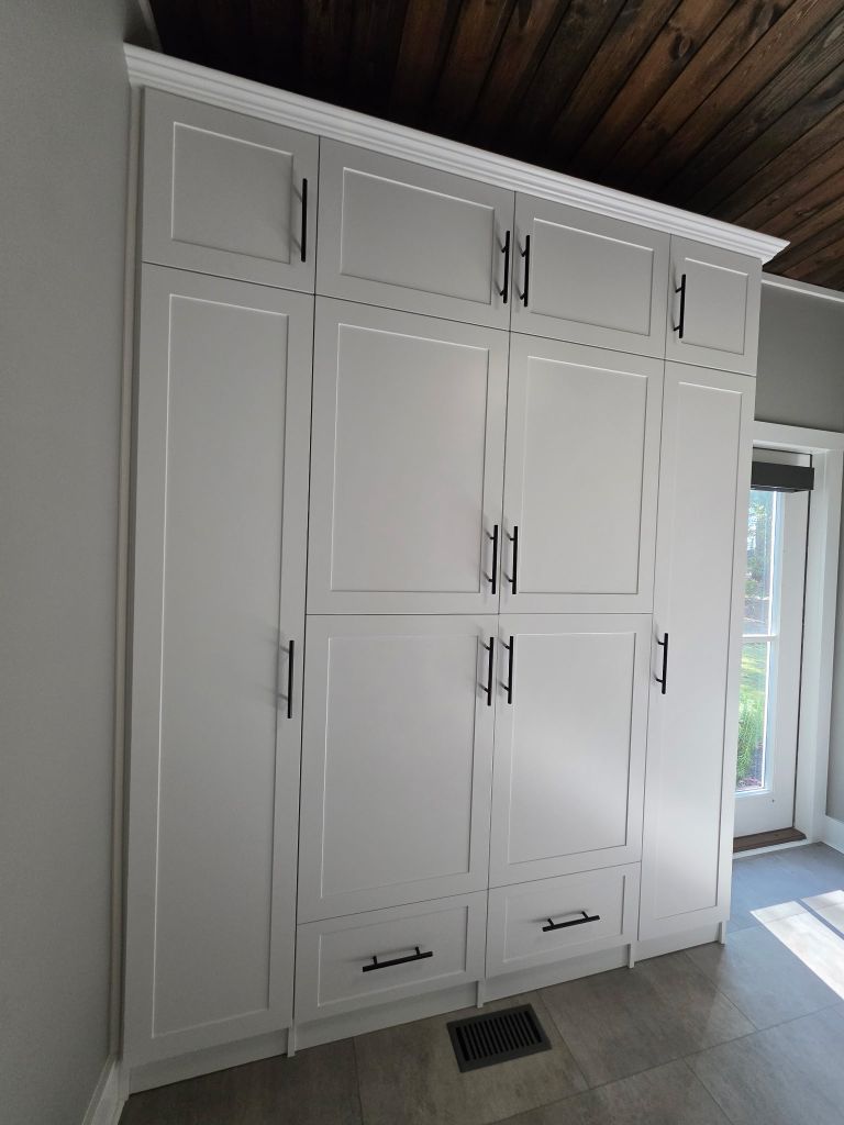 White built-in cabinets with silver handles in a room.
