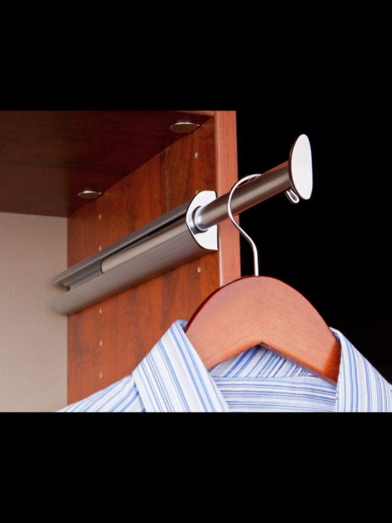 A striped shirt hanging on a wooden hanger on a metal rod.
