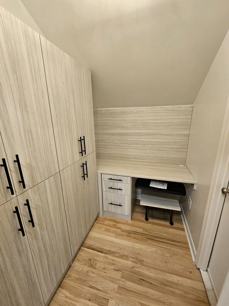 Small room with wooden closets and a built-in desk area.