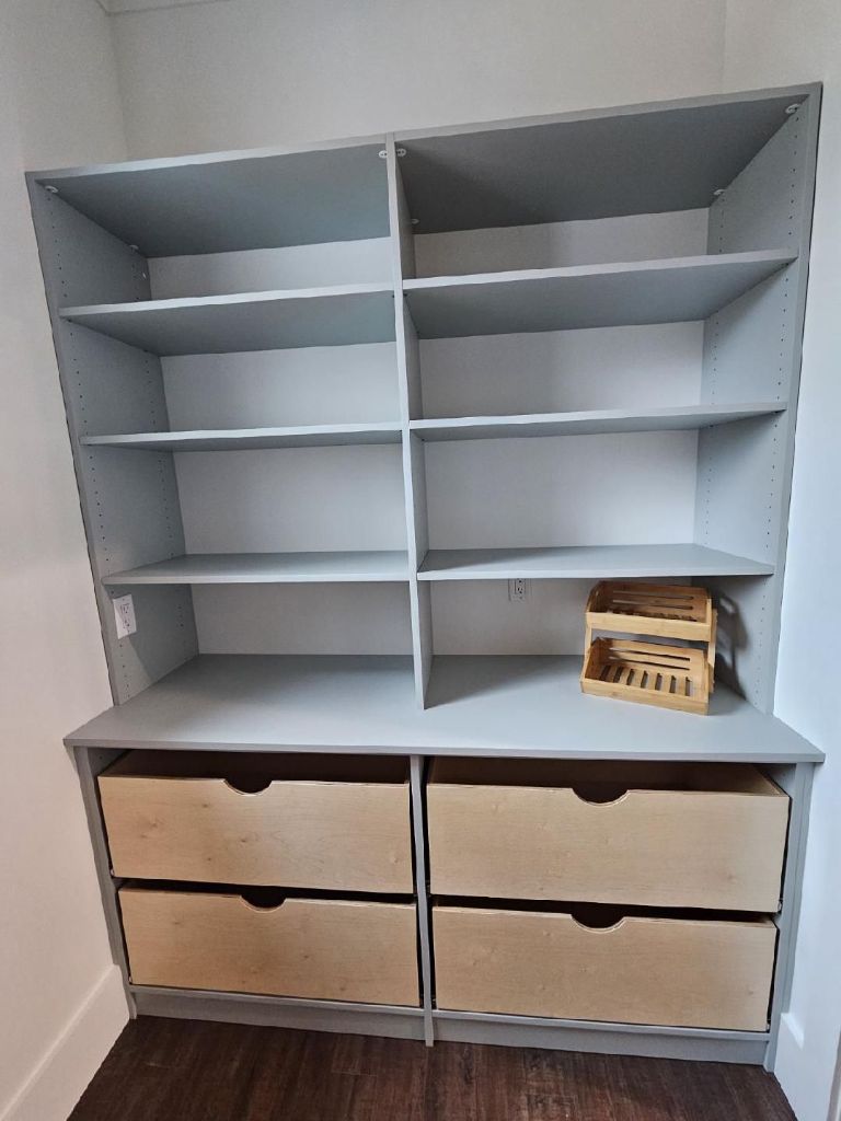 Wooden shelving unit with drawers and compartments, partially filled with a basket.