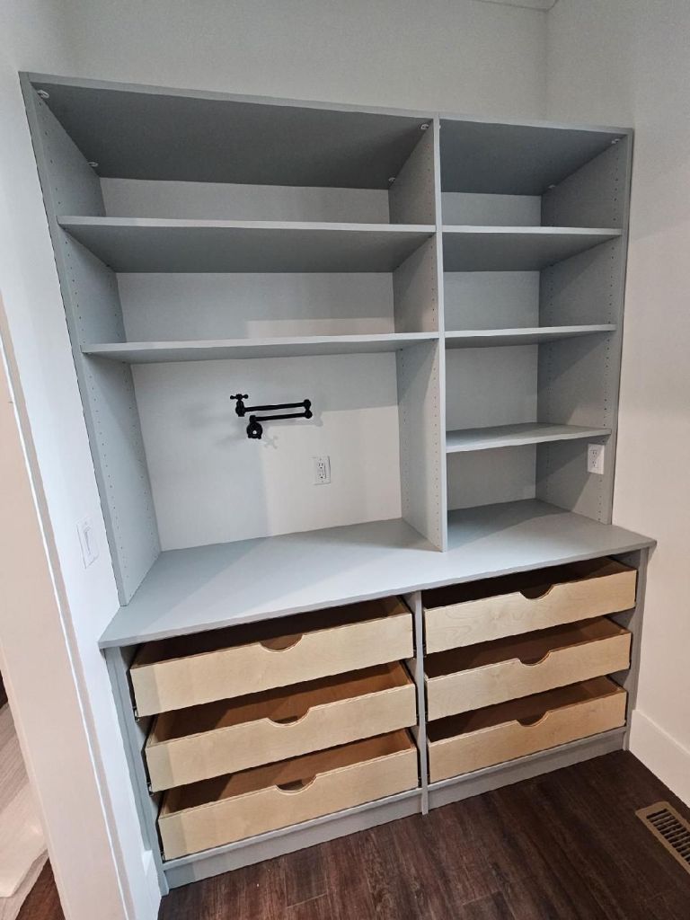 Empty wooden shelving unit with drawers and adjustable shelves.